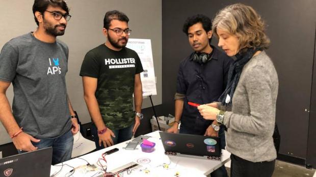 Swapnesh Wani, Purva Patel, and Supreeth Kumar demonstrate their flying mobile case to Associate Professor Anne-Laure Fayard at the Prototyping Fund Showcase