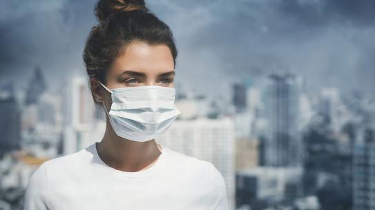 woman wearing mask in city smog