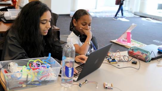 Two Science of Smart Cities students program an Arduino board. 