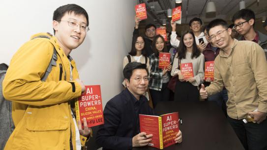 Kai-Fu Lee with group of students all holding his book