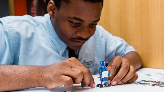 excellence boys student assembling a robot