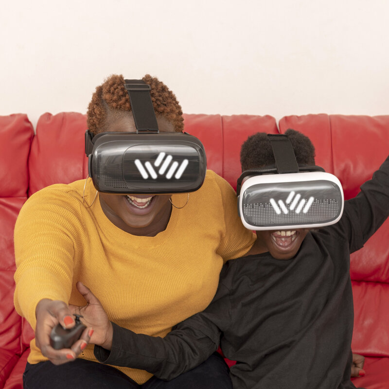 A women and a kid playing VR on a red couch 