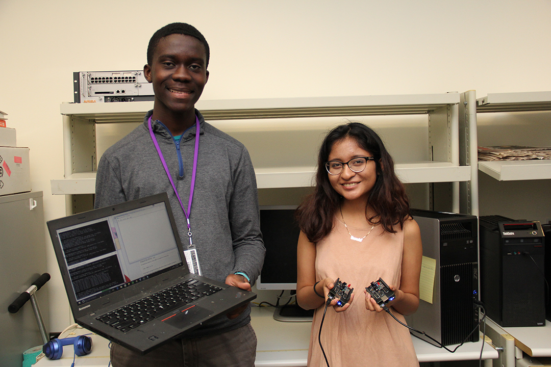 students holding up a laptop and circuits 