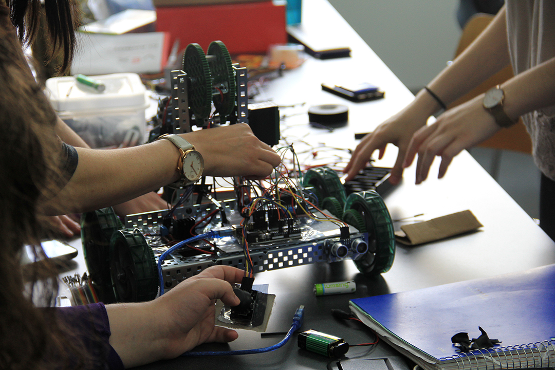 closeup of hands constructing a robot