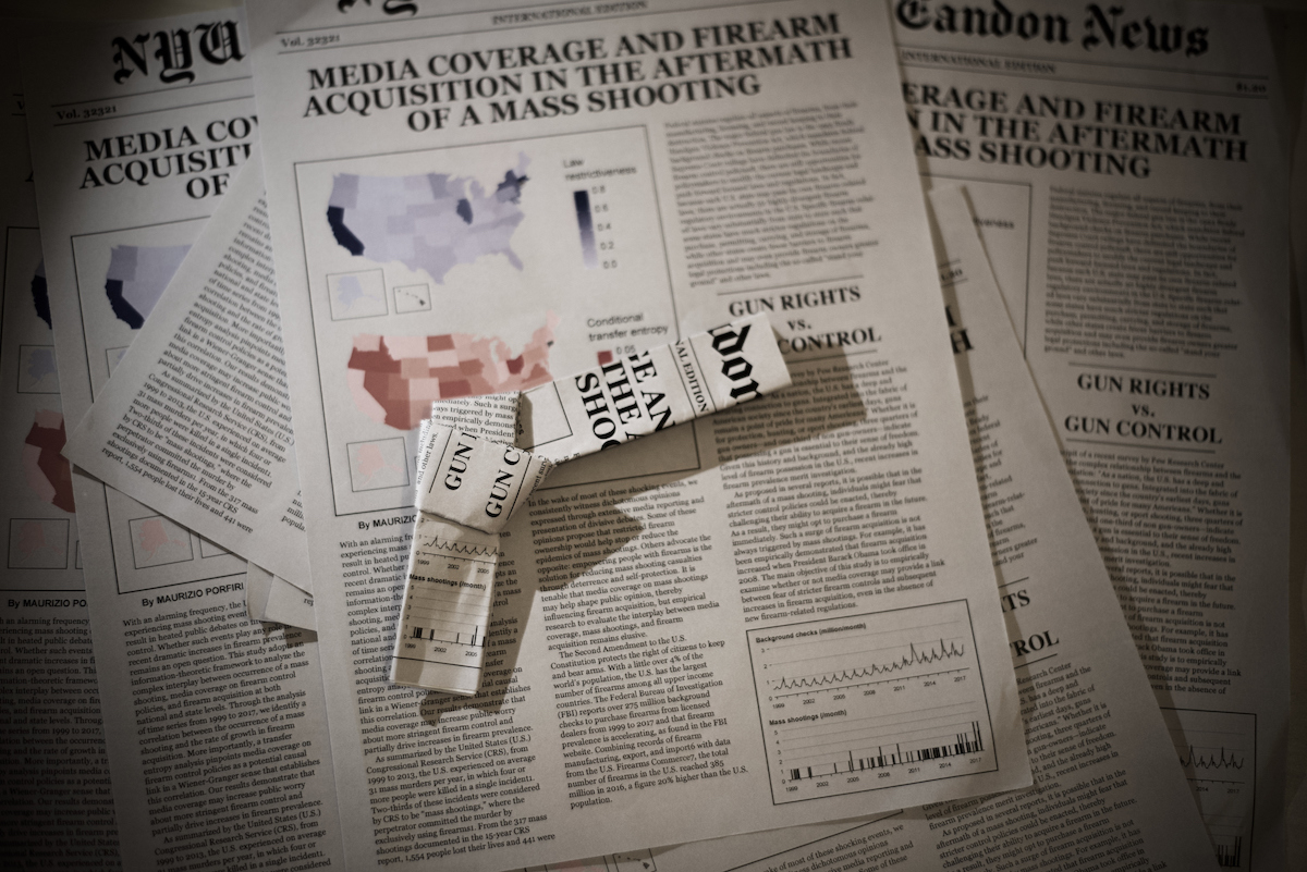 newspaper folded to look like a gun