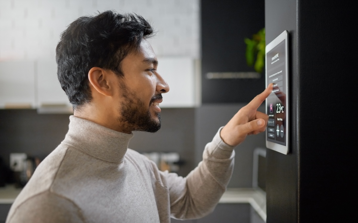 man interacting with touch screen on a fridge