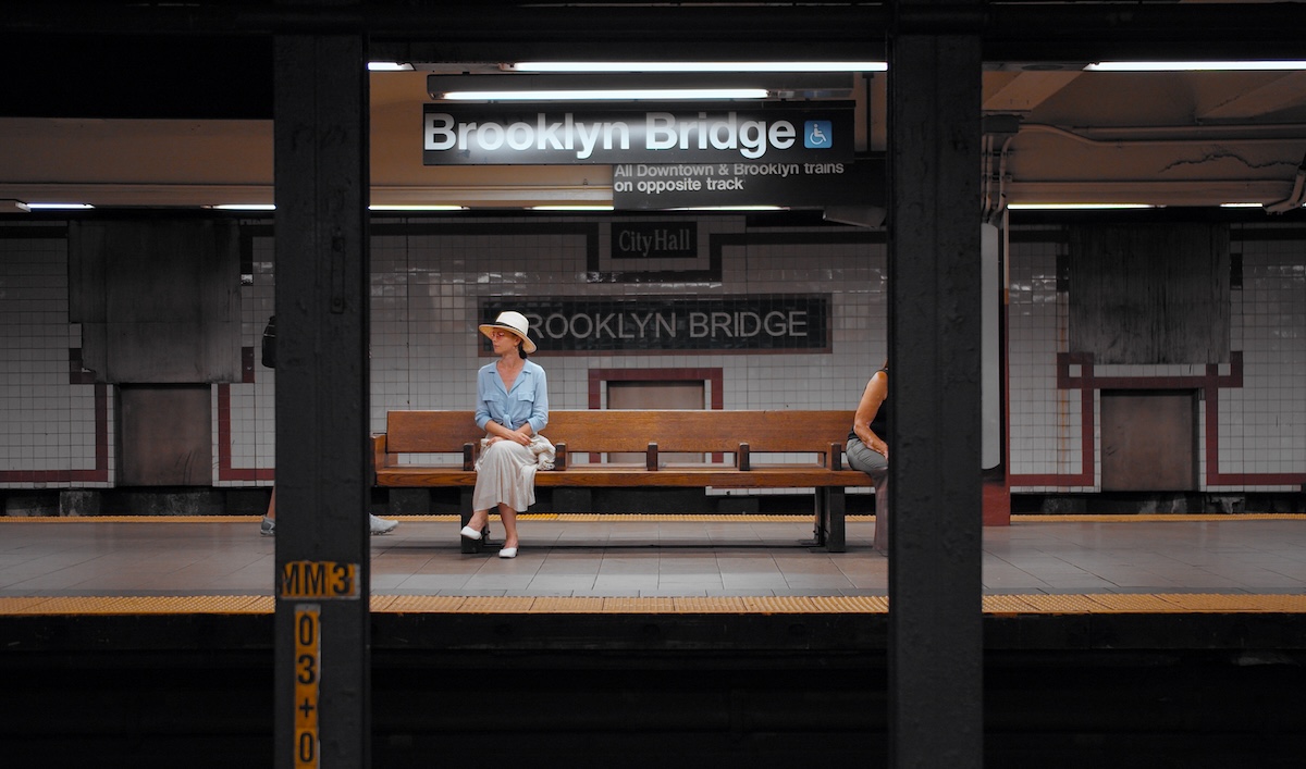 woman sitting on bench on subway platform in Brooklyn