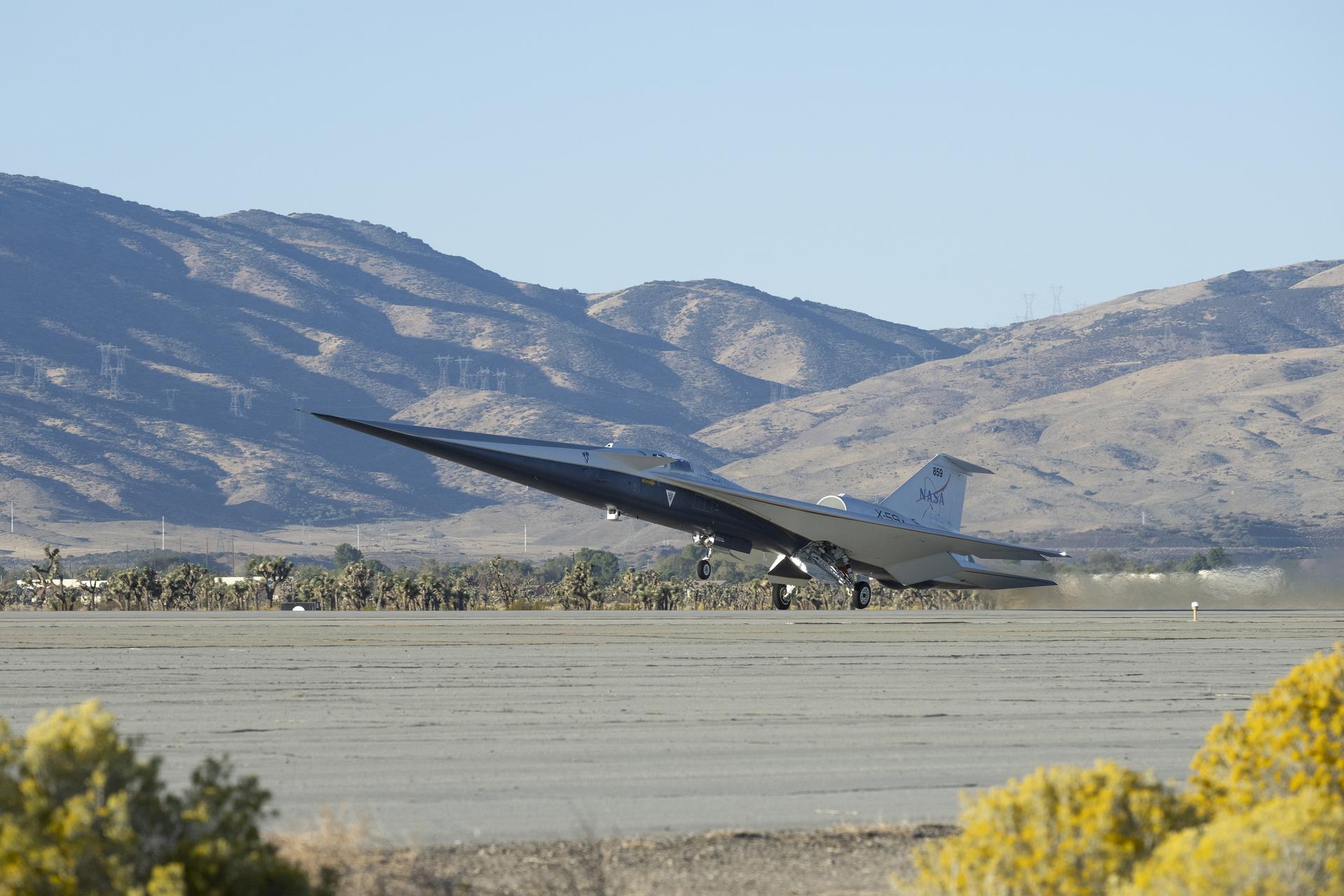Silver X-59 airplane, featuring a notable long nose, taking off from a remote area.