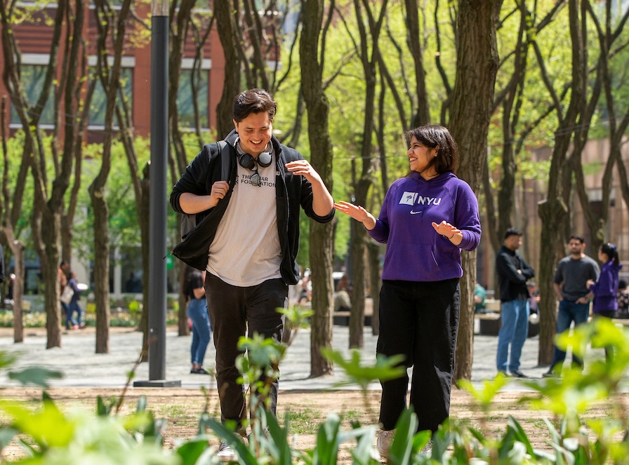 two students walking through Brooklyn Commons in Spring