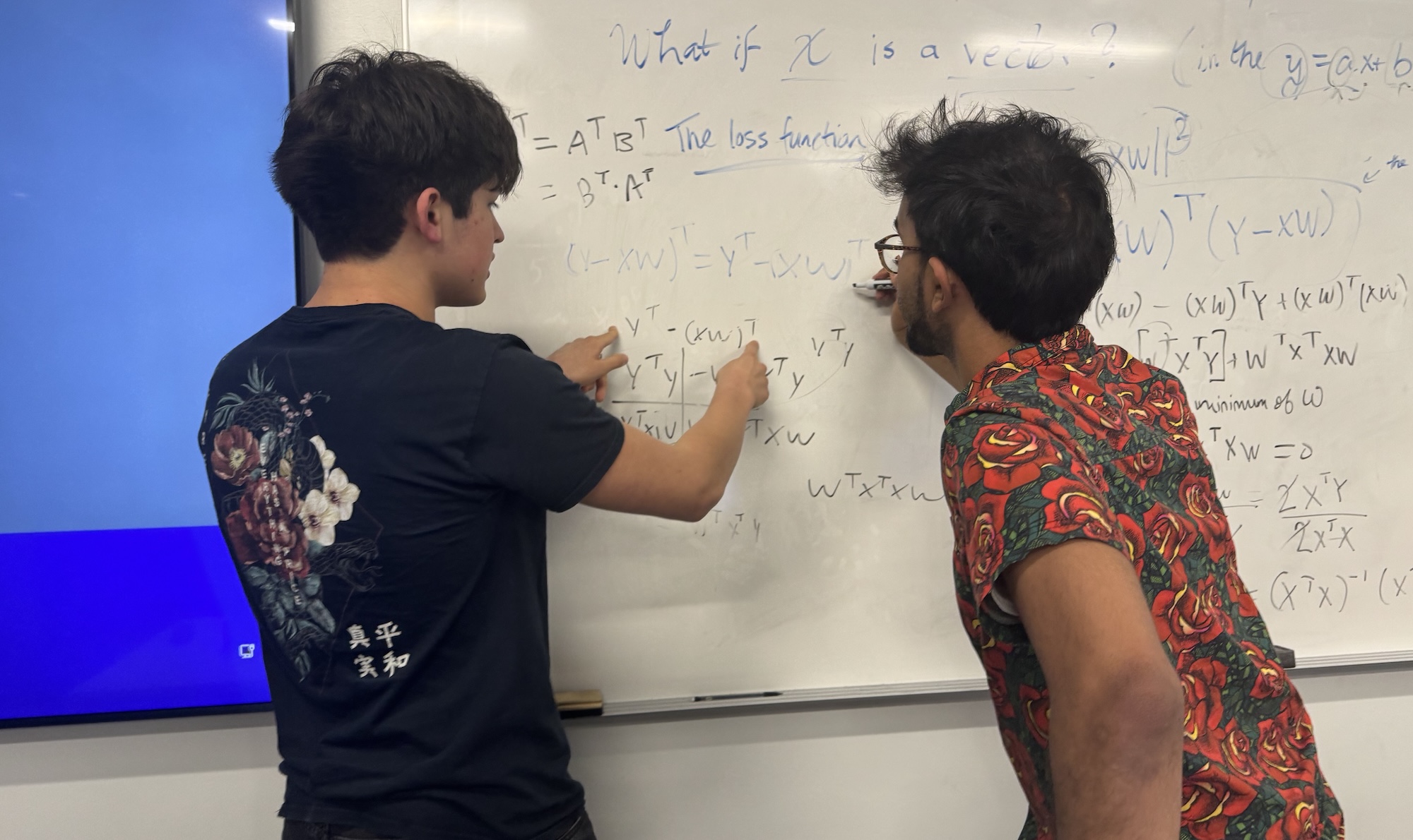 two students solving math at whiteboard