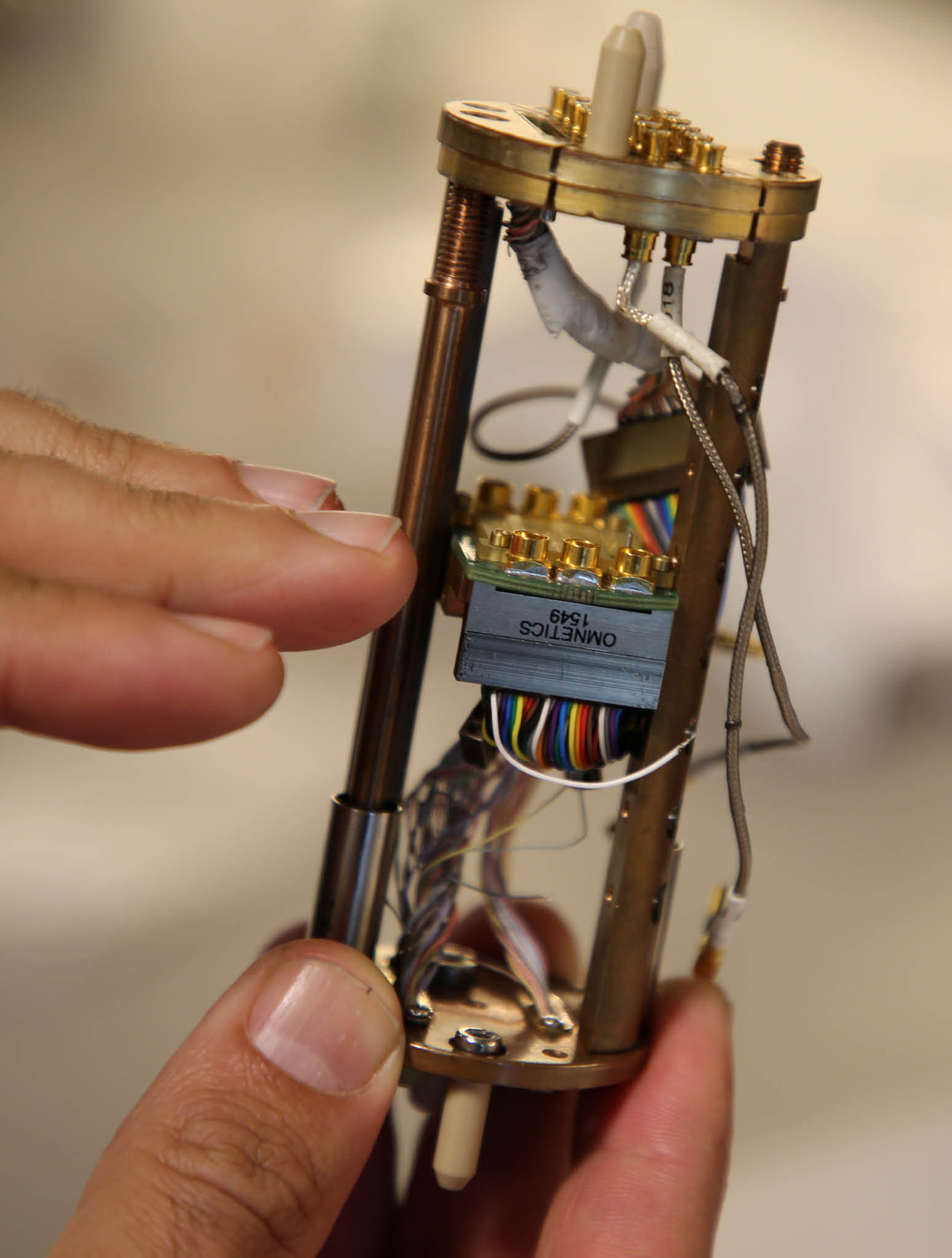 Hands holding an electronic research probe component