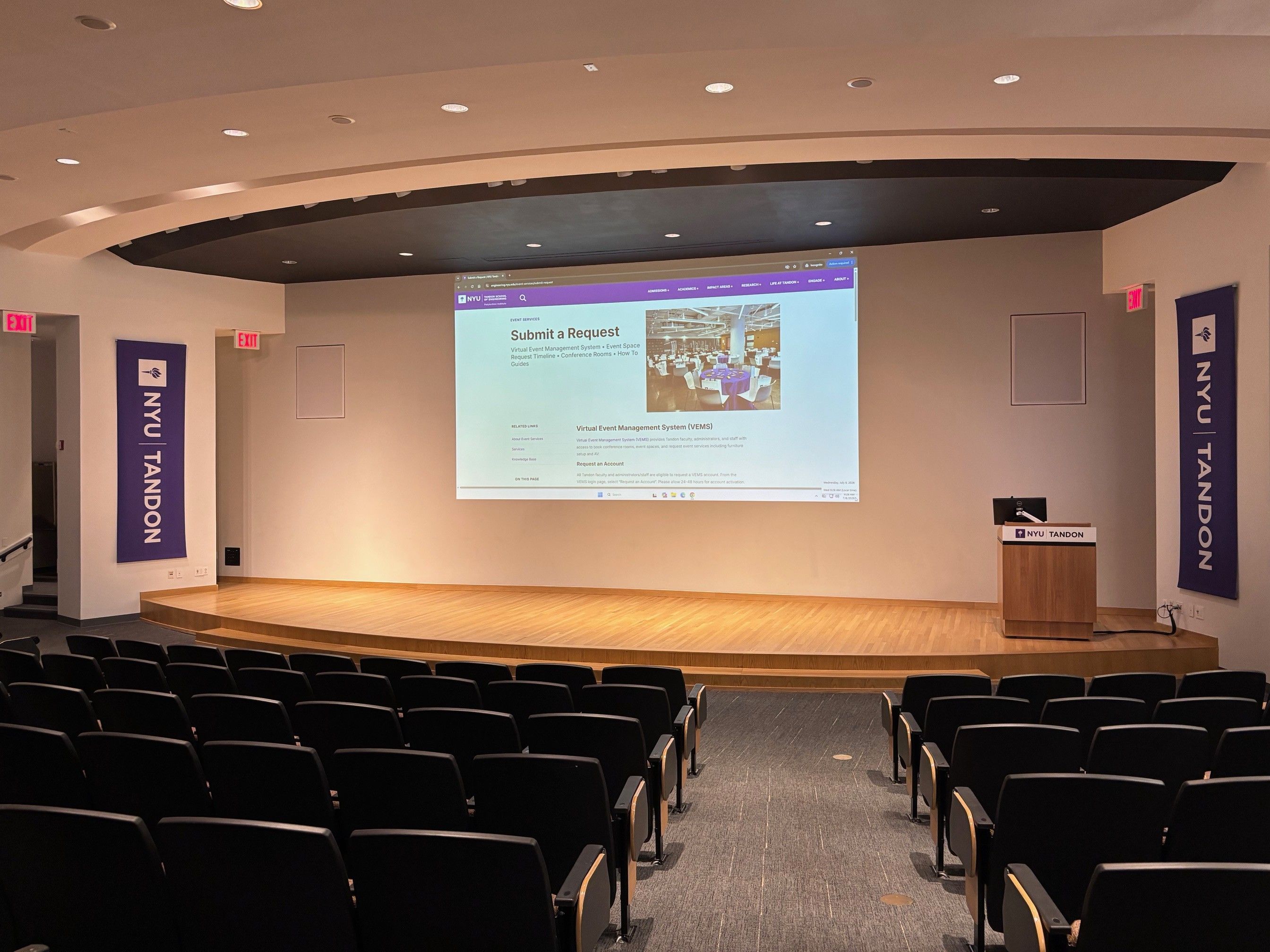 Auditorium stage with NYU Tandon banners