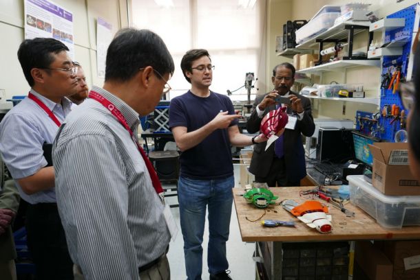 Jeffrey Laut (center) explains how robotic fish work during a lab tour for the Mechatronics education workshop.