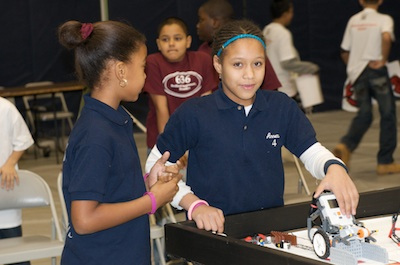 Two students prepare their robot for competition