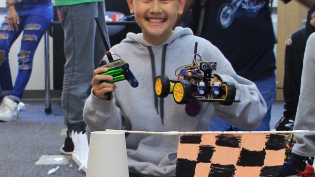 student holding up a circuit car 