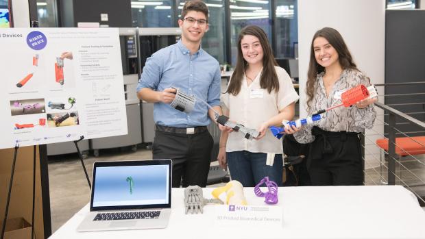 students holding 3d printed devices 