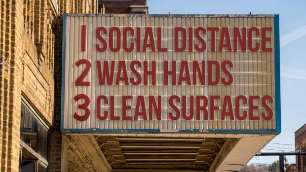 Movie marquee reading: "Social Distance, Wash Hands, Clean Surfaces"
