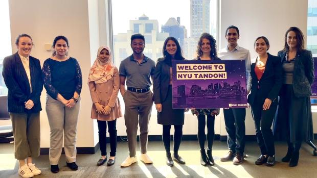 diverse group of young academics with faculty holding welcome sign