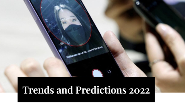 A person setting up the face recognition in their phone. There also some text saying: "Trends and Predictions 2022"