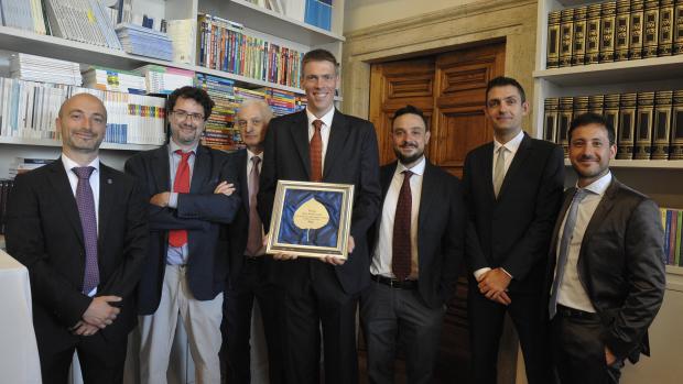 group of scientists in suits holding an award plaque 