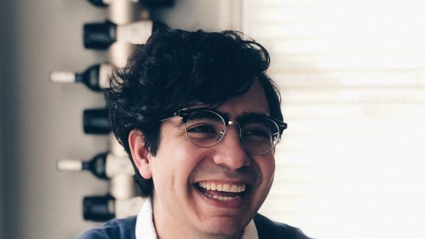 Smiling Sebastian Romero Cruz with a cup of coffee