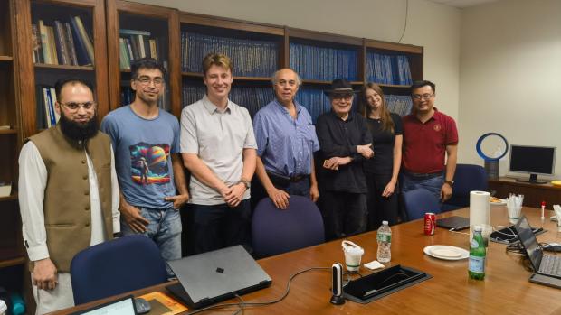 group members standing behind a meeting table