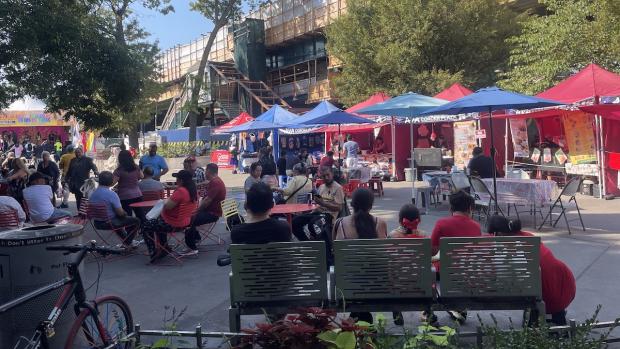 people sitting outside under sun umbrellas