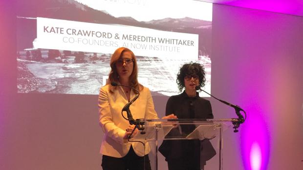 Kate Crawford and Meredith Whittaker speaking at a podium