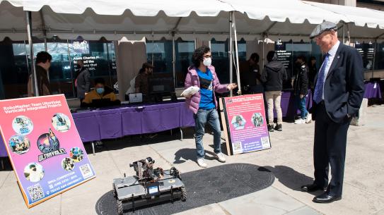 A student controls a roving robot with remote control 