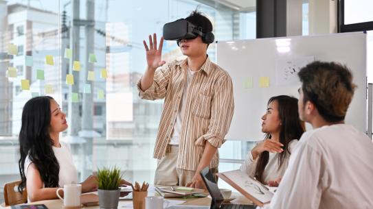 image of team meeting with man staring into VR headset