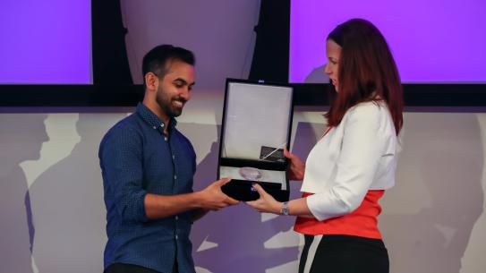 Devjoy receiving an award on stage