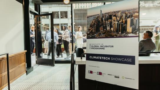 poster board for climate-tech showcase outside crowded reception