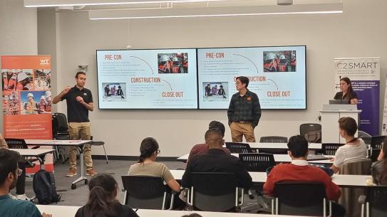 Representatives from construction campany giving presentation to full room of students