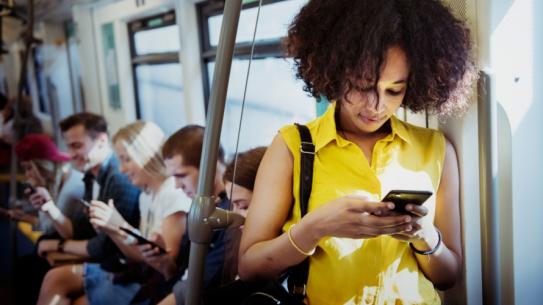 woman on subway looking at her phone