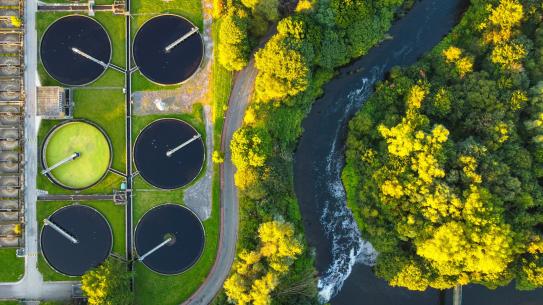 birds eye view of waste treatment plant next to a river