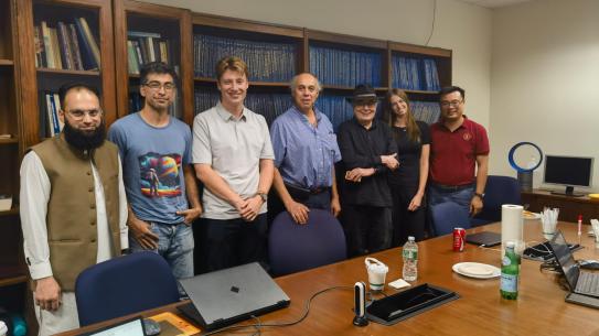 group members standing behind a meeting table