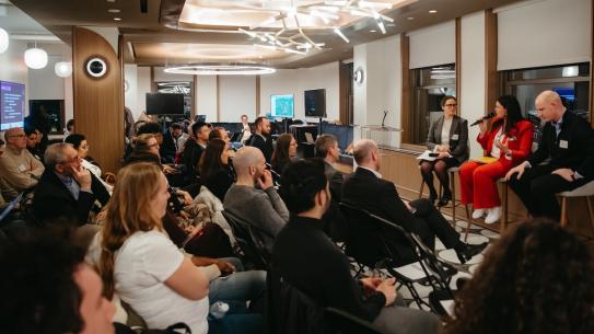 a panel of speakers addressing a packed audience