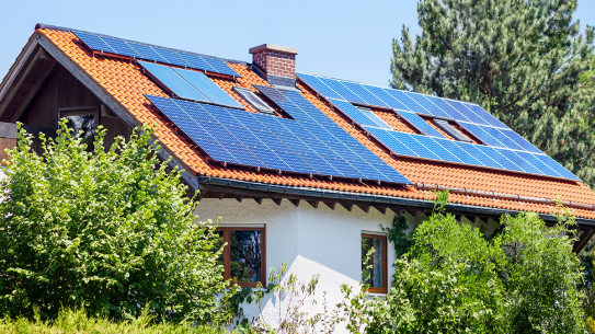 An older home with solar panels installed on the roof.