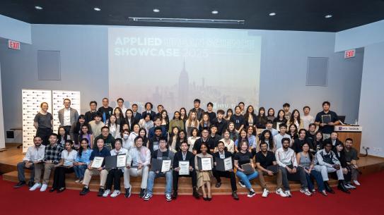 Urban Data Science Class of 2025 sitting on the stage of Pfizer Auditorium
