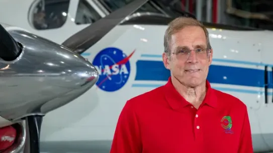 Peter Coen standing in front of a white airplane with the NASA logo on it 