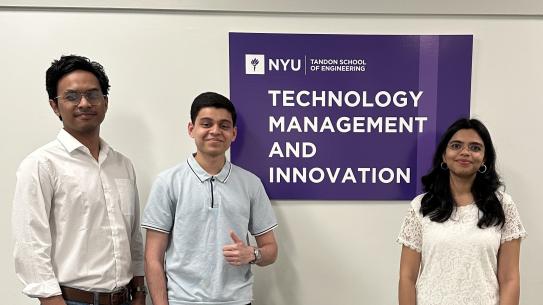 three students standing by Technology, Management and Innovation Department sign