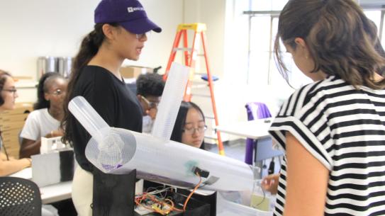A student instructor demonstarting an engineering project. 