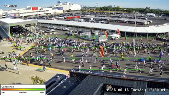 a crowd of pedestrians walking near a stadium with arrows indicating movement