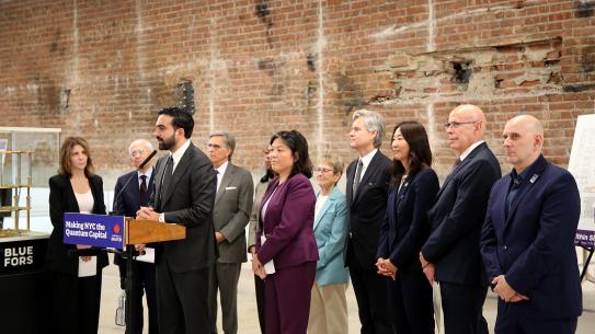 Mayor Mamdani stands at a podium in front of a quantum chiller.