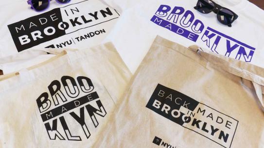 a pile of Tandon t-shirts and tote bags