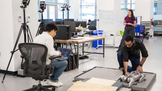 students working on a robot in a lab