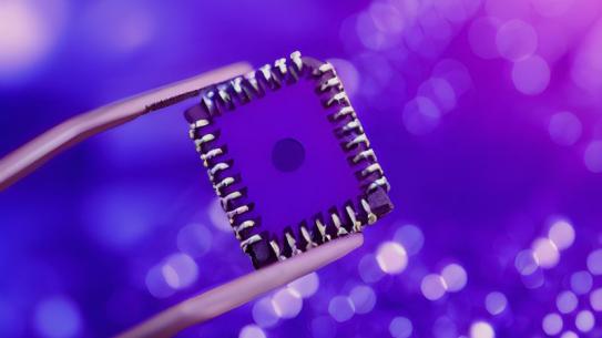 computer chip being held by tool