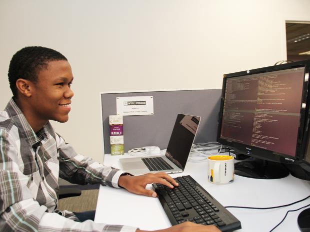student coding on a desktop