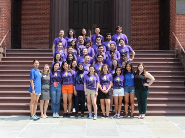  group of students wearing orientation shirts on steps of Wunsch Building