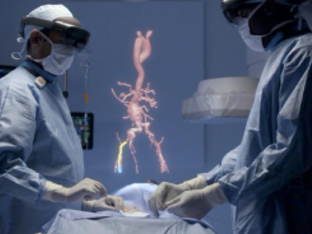 Two doctors in surgery using augmented reality, viewing 3-D recreations of organs
